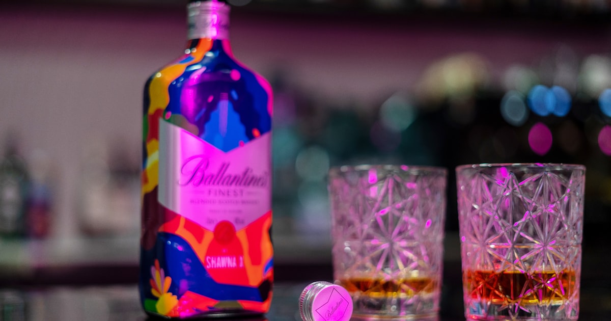 A bottle of alcohol sitting next to two glasses