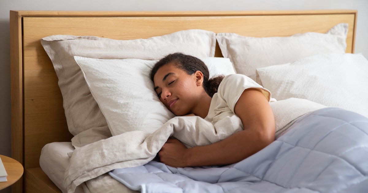 Person sleeping peacefully in bed with white sheets